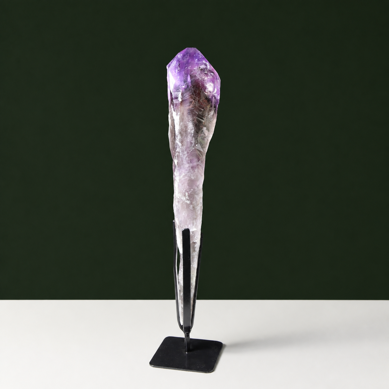 Slender naturally terminated amethyst point on black metal stand