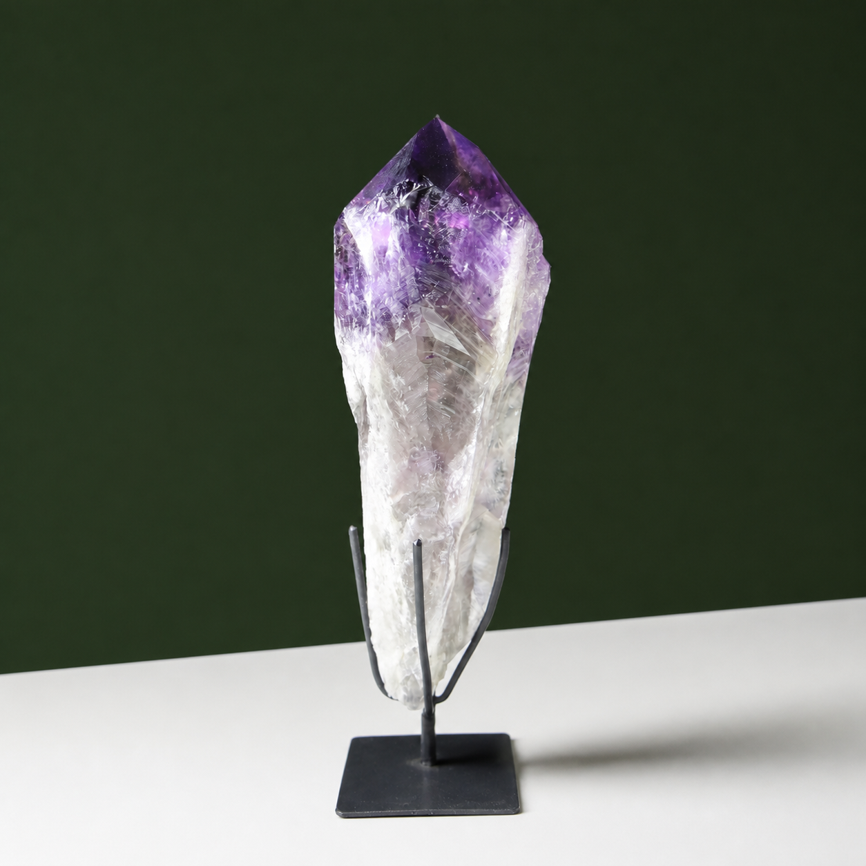 Deep purple naturally terminated amethyst wand on black metal stand