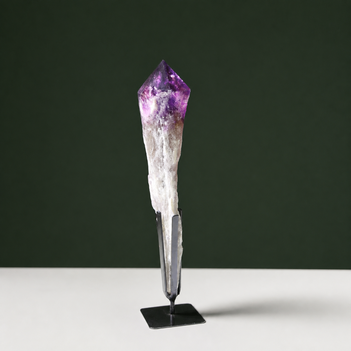 Deep violet naturally terminated amethyst wand on black metal stand