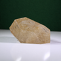 Polished rutilated quartz freeform, 1.258 kg, main view on a white surface with a dark green background.