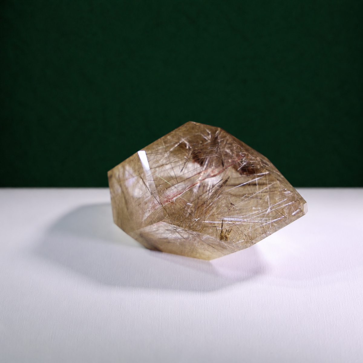 Polished rutilated quartz freeform, 417 g, side view showing natural rutile inclusions.