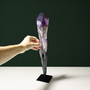 Amethyst wand with growth markings shown with hand for scale