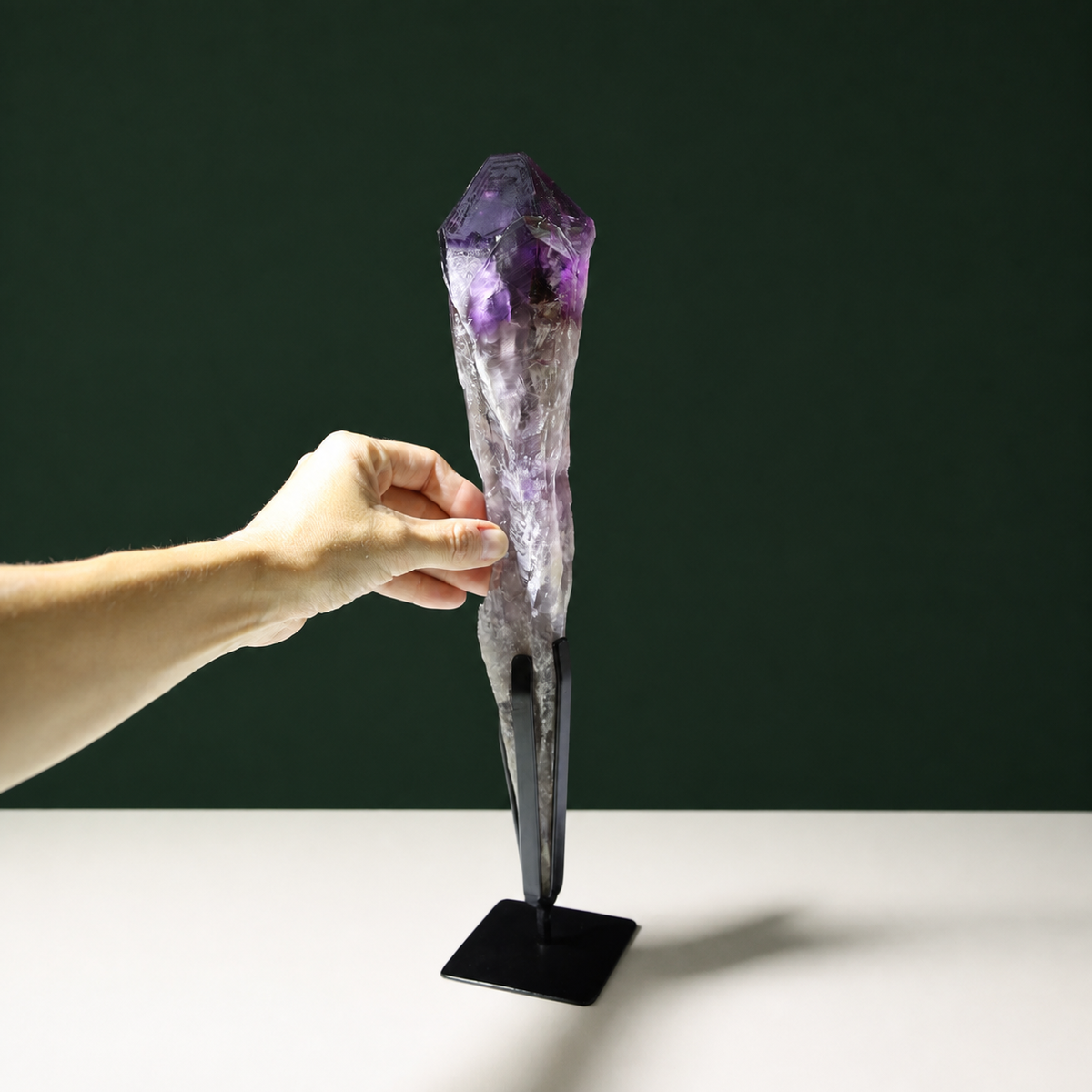 Amethyst wand with growth markings shown with hand for scale