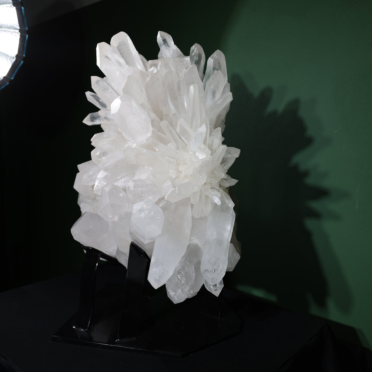 Full angled view of the quartz cluster on its black stand
