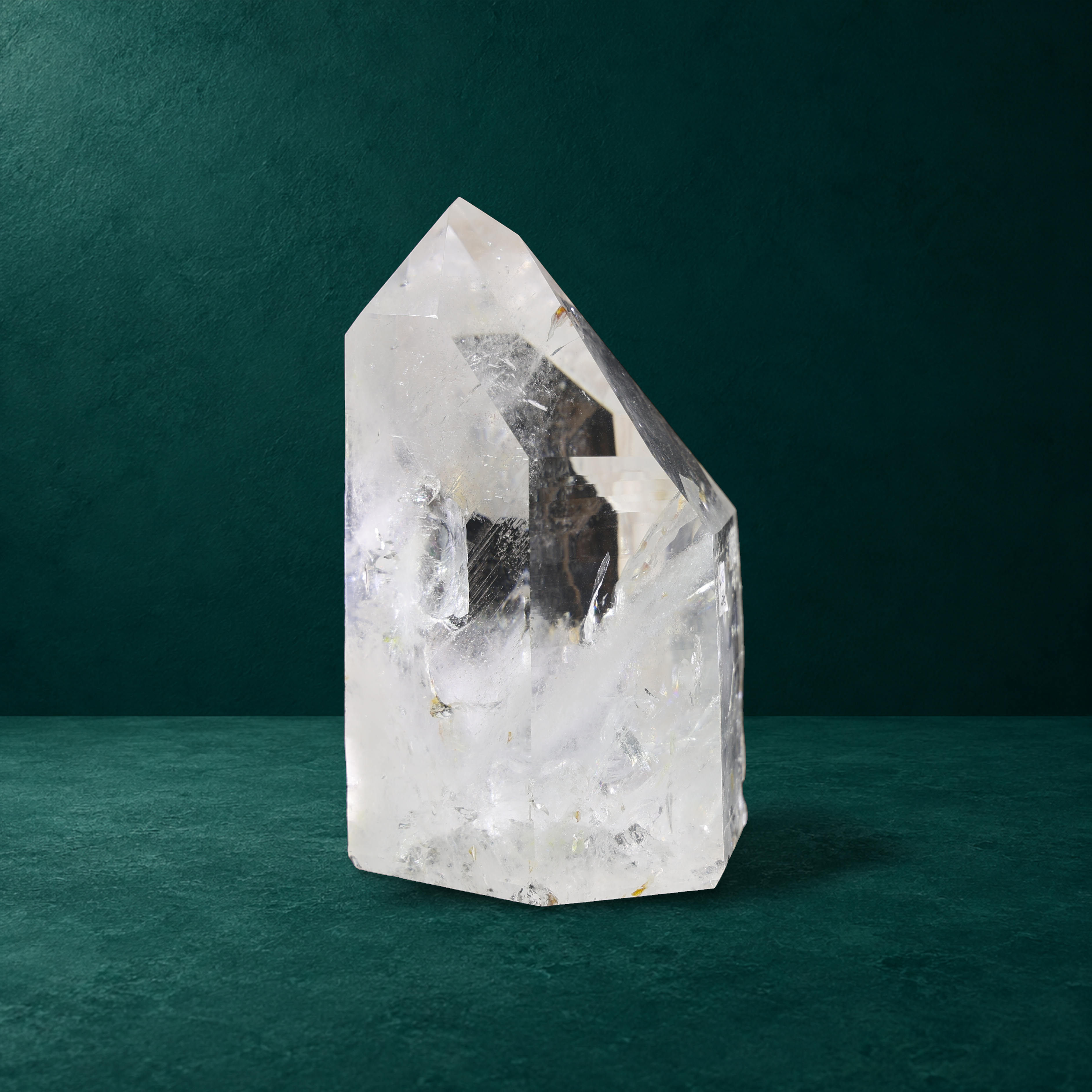 Polished quartz point, 4.670 kg, showing side facets and internal inclusions.