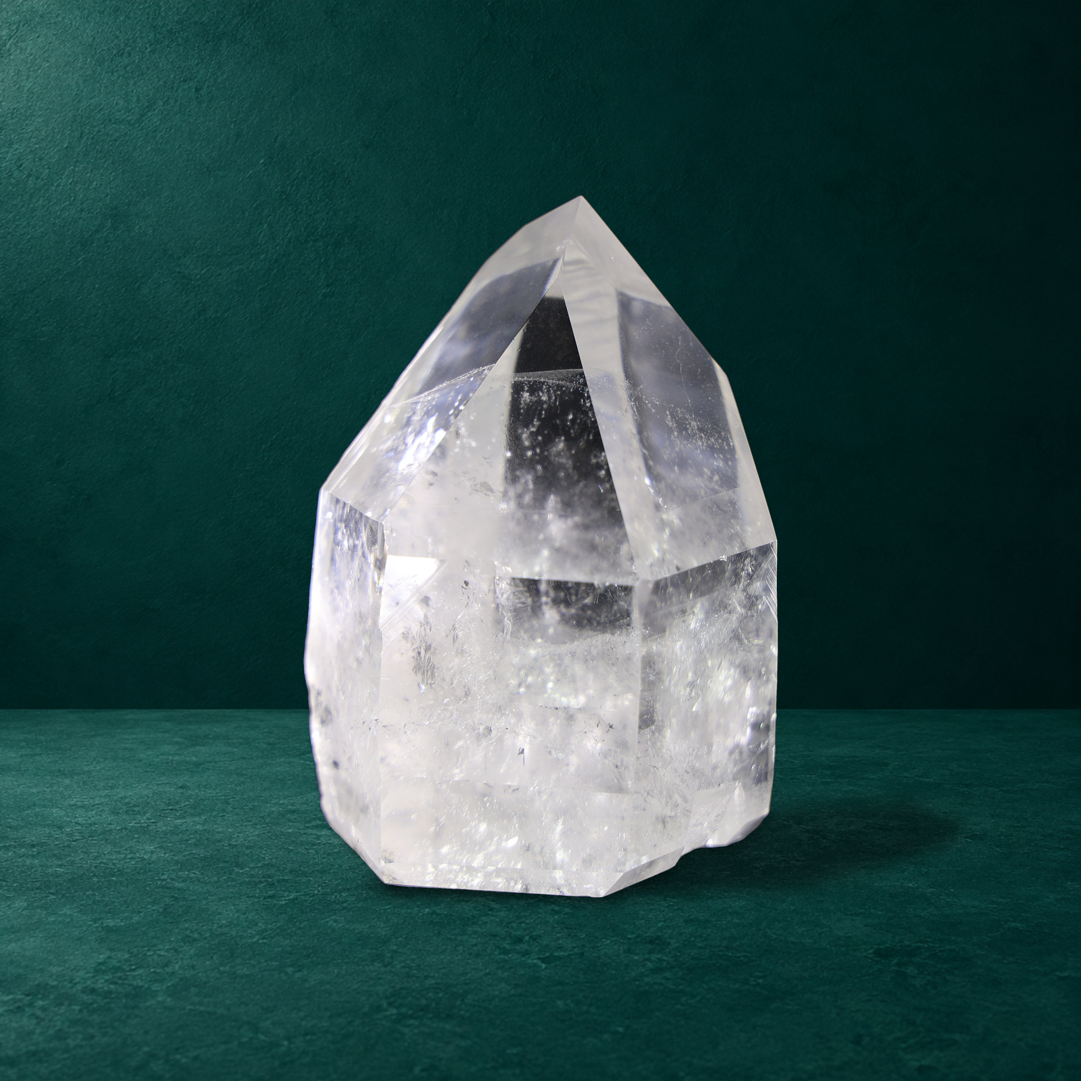 Side view of the 1.079 kg polished quartz point showing its facets and internal inclusions.