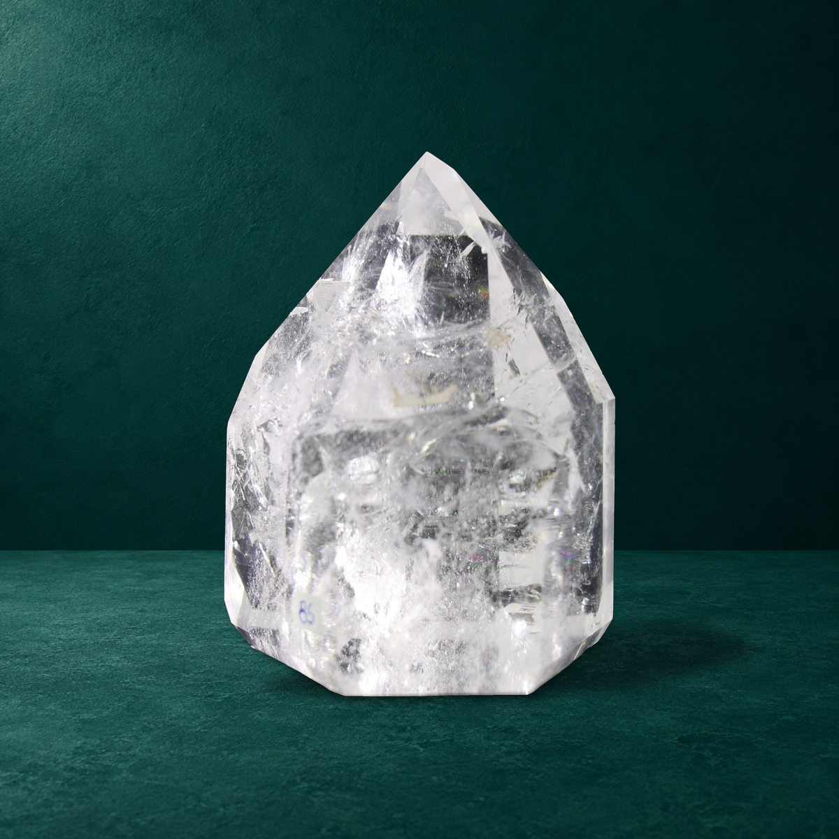 Polished quartz point showing broad facets and internal inclusions.