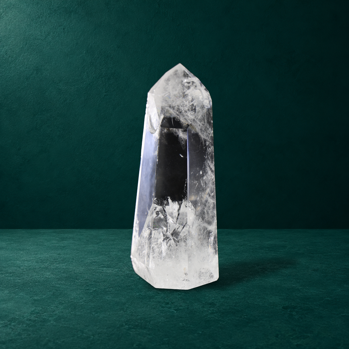 Polished quartz point showing transparent areas and white internal inclusions.
