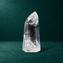 Polished quartz point showing its tip and white inclusions near the base.
