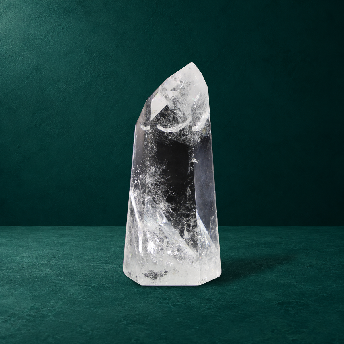 Polished quartz point showing its tip and white inclusions near the base.