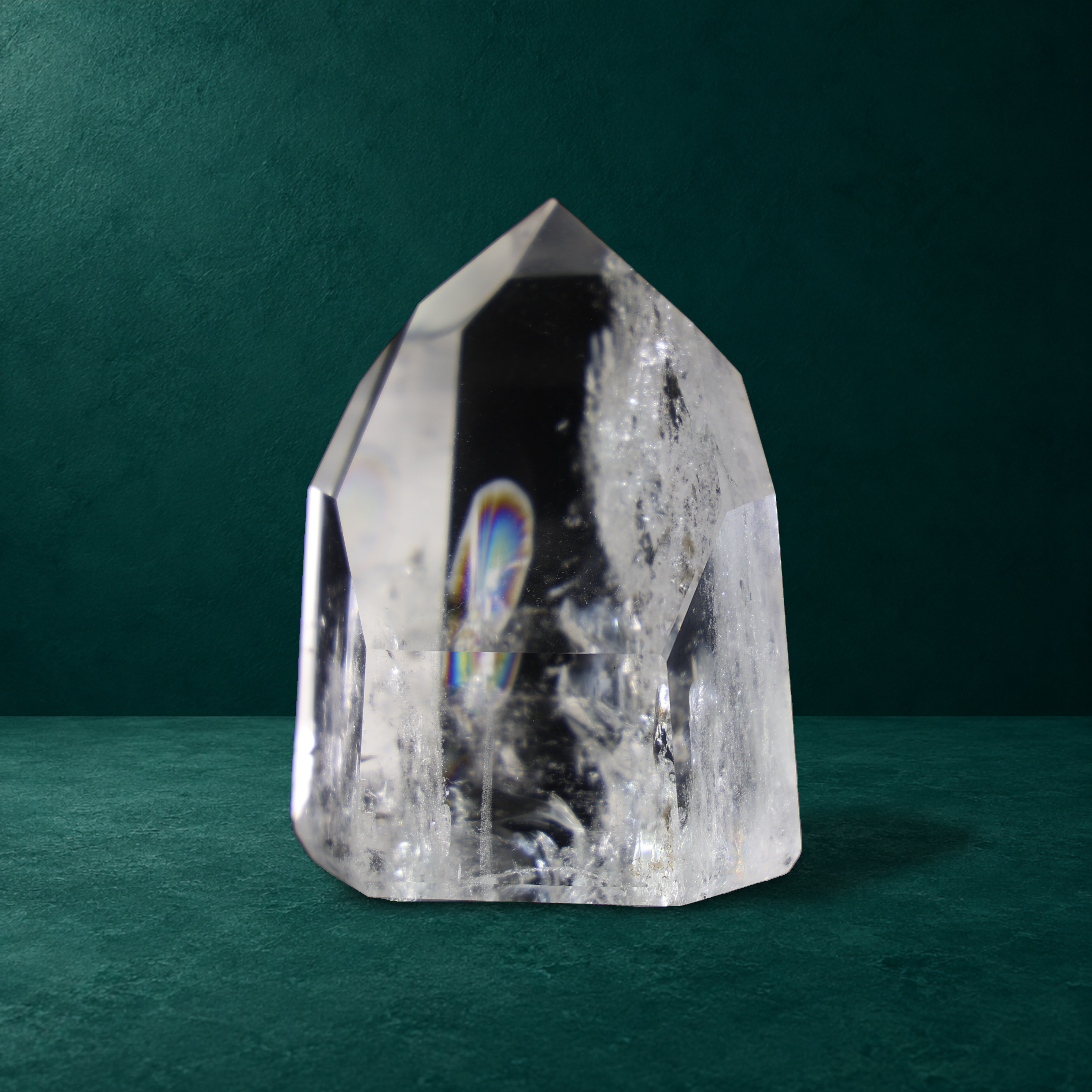 Polished quartz point with a visible rainbow, 0.575 kg, front view.