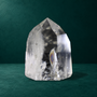 Polished quartz point with rainbow reflections visible inside.