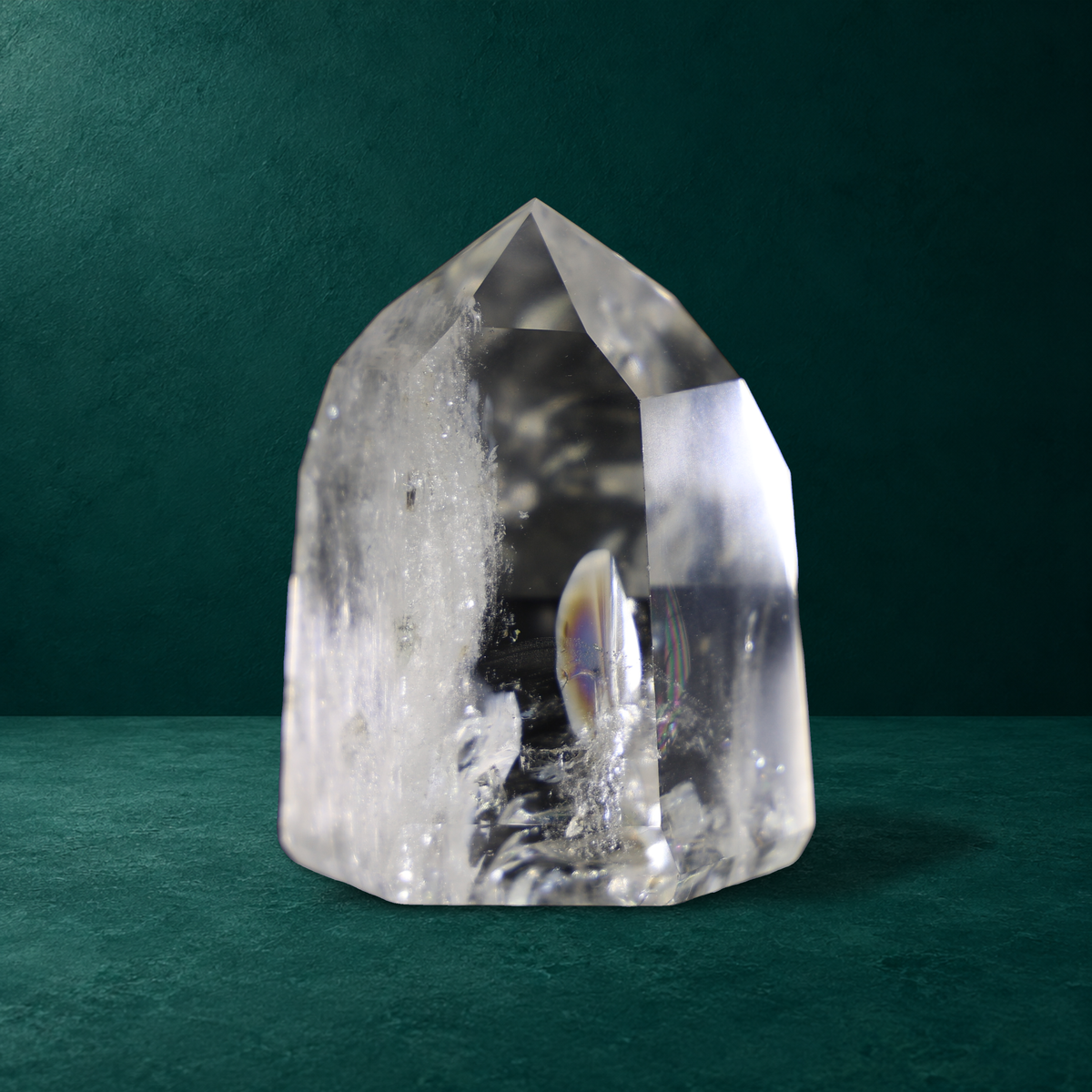 Polished quartz point with rainbow reflections visible inside.