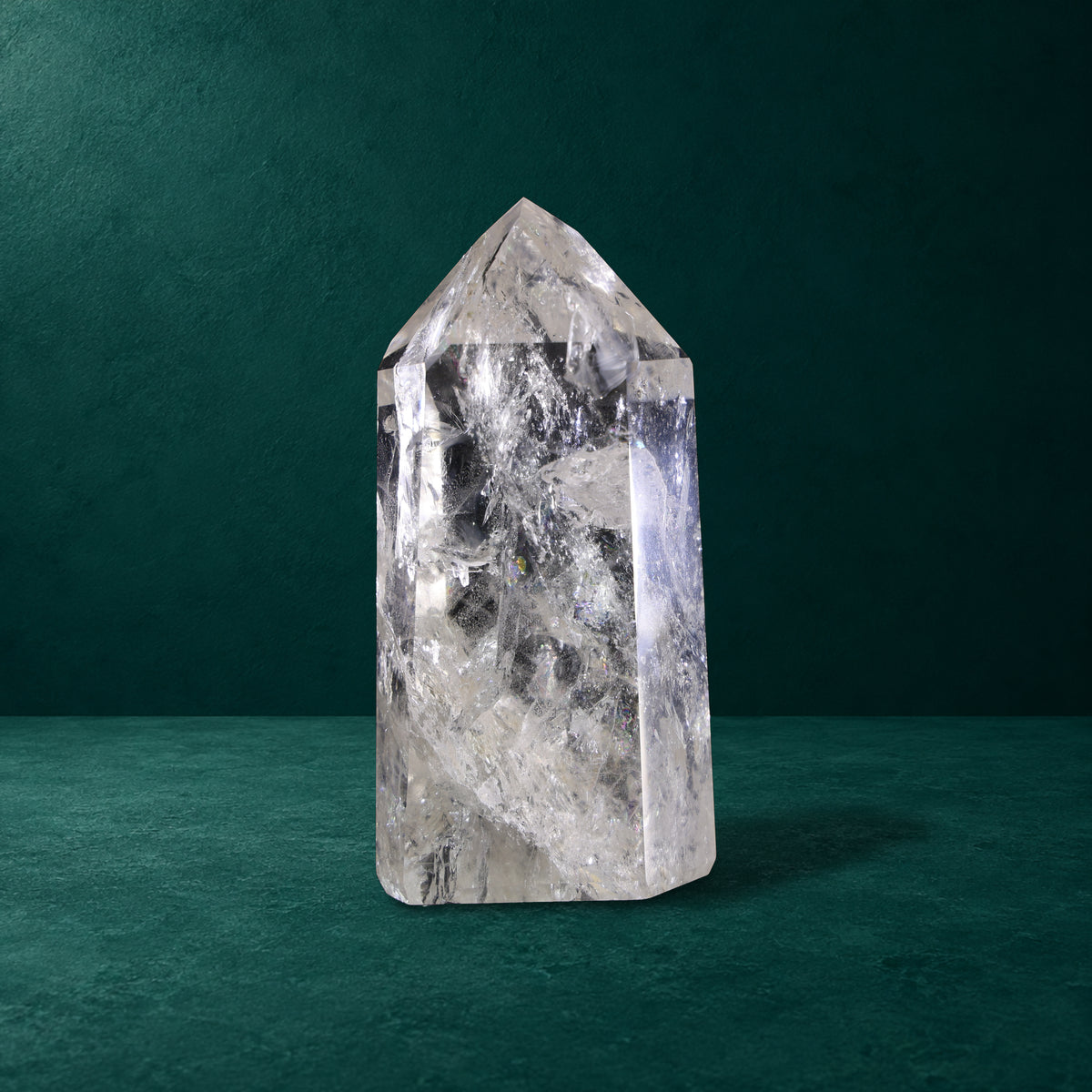 Polished quartz point showing broad facets and internal patterns.