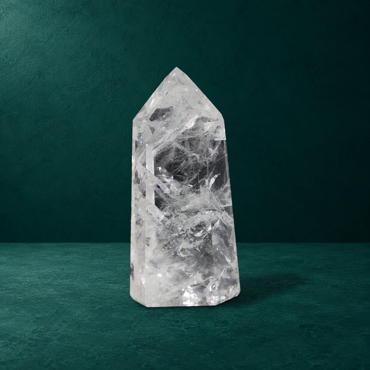 Polished quartz point showing broad facets and internal patterns.