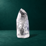 Polished quartz point showing broad facets and internal inclusions.