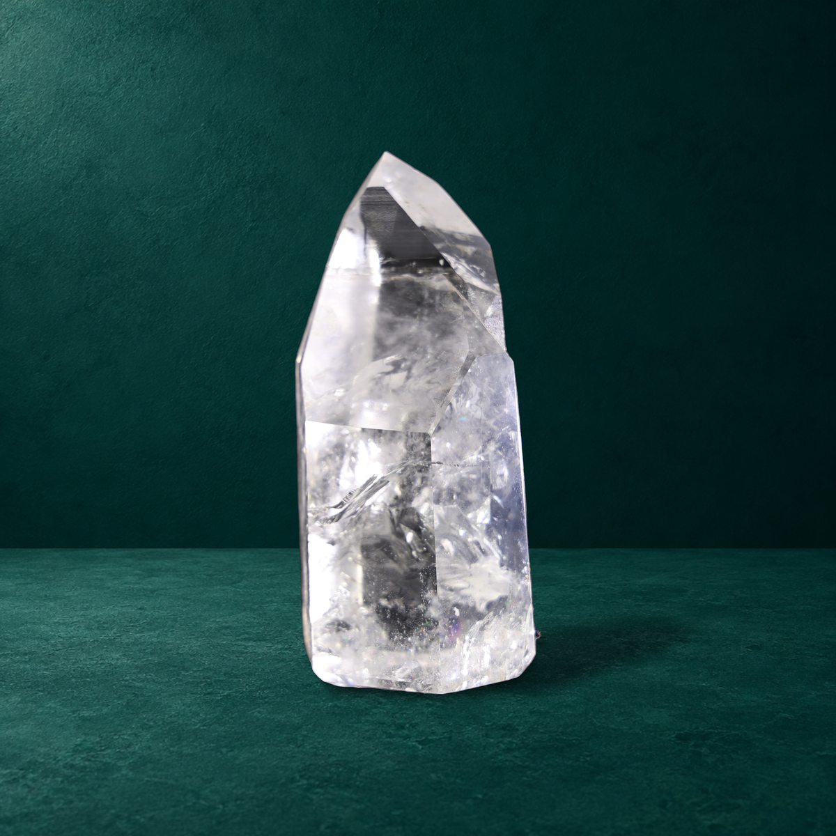Polished quartz point showing broad facets and internal inclusions.