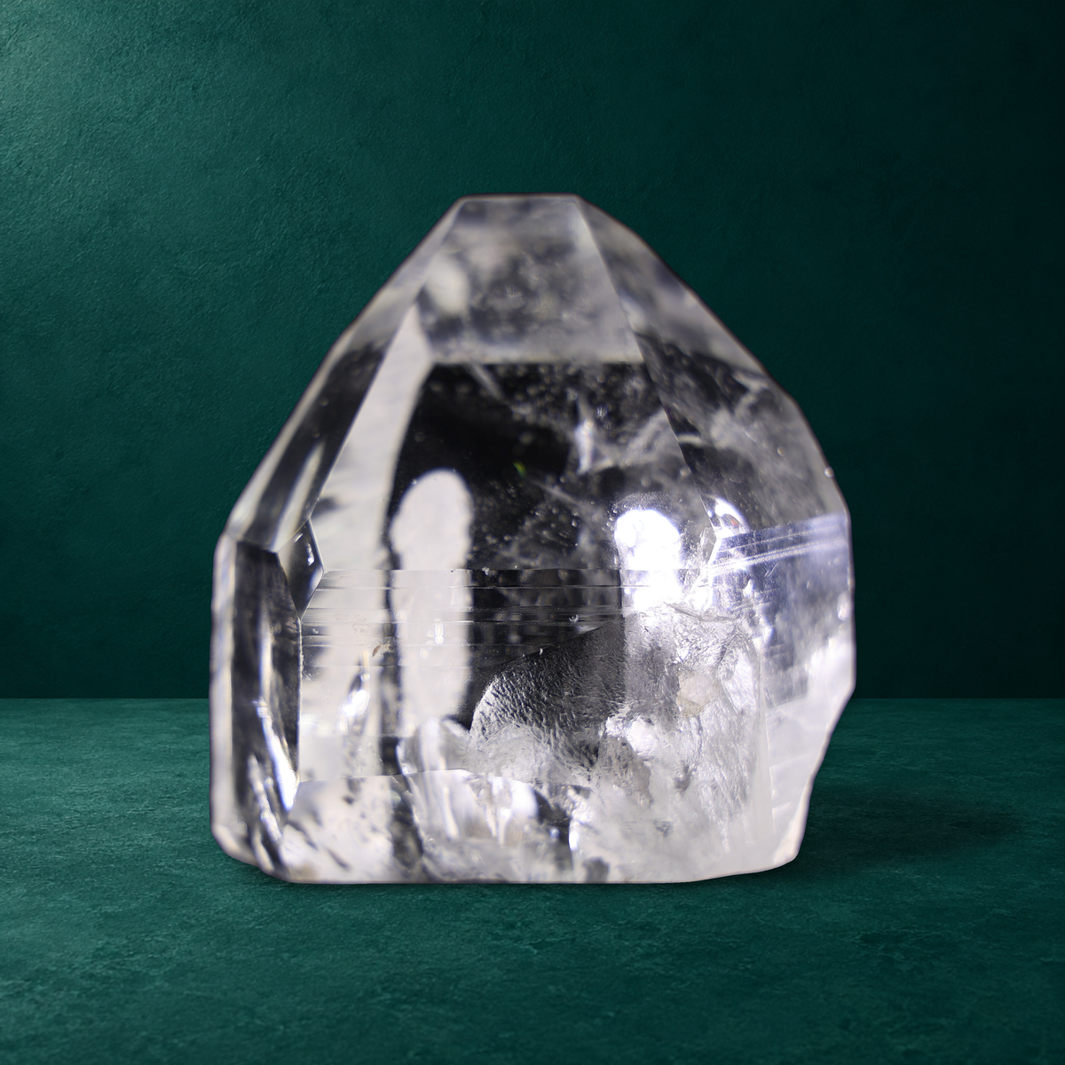 Polished quartz point, 0.760 kg, front view with natural regrowth