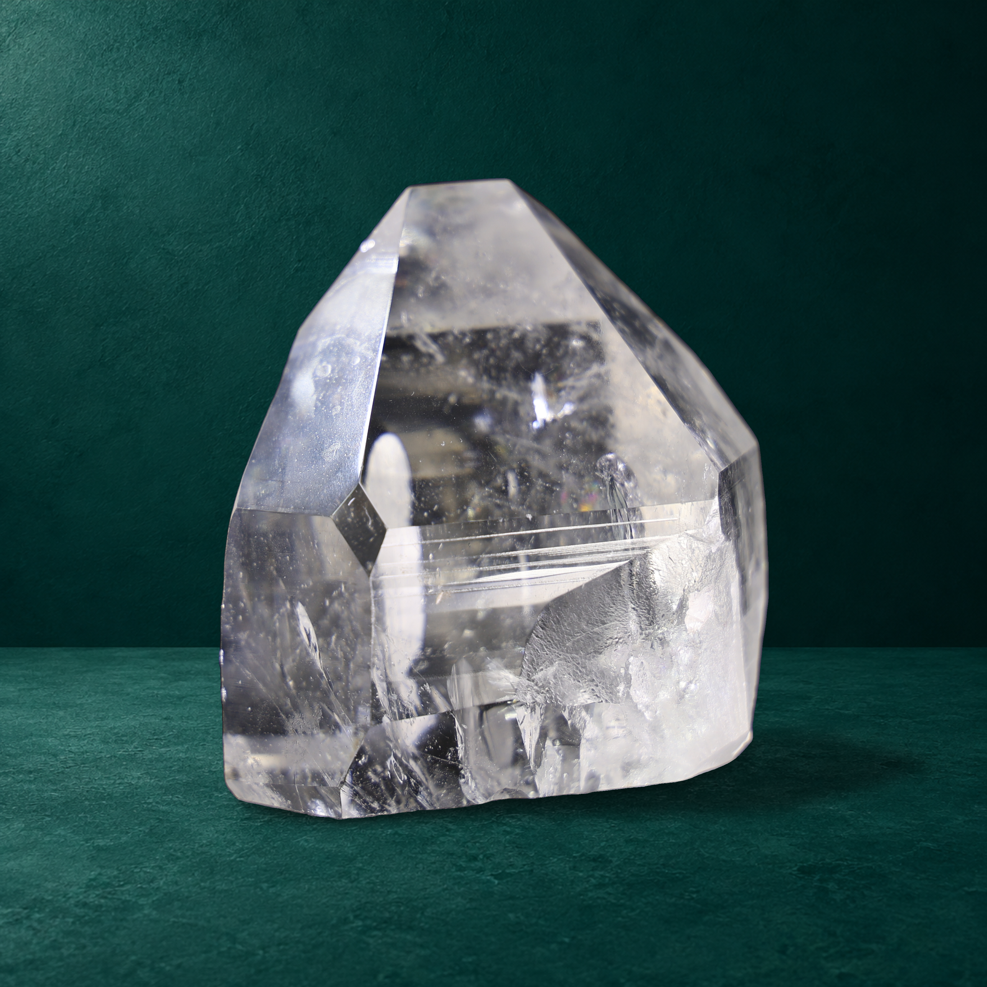 Polished quartz point, 0.760 kg, angled view with horizontal striations