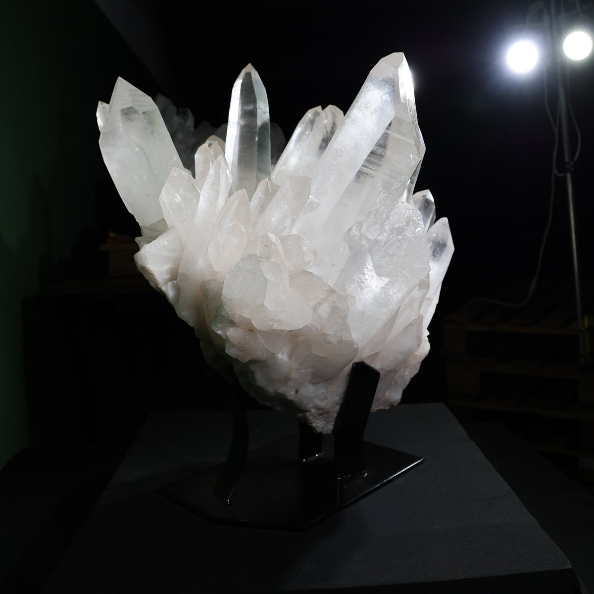 Hand shown beside the crystal points as a visual reference for scale